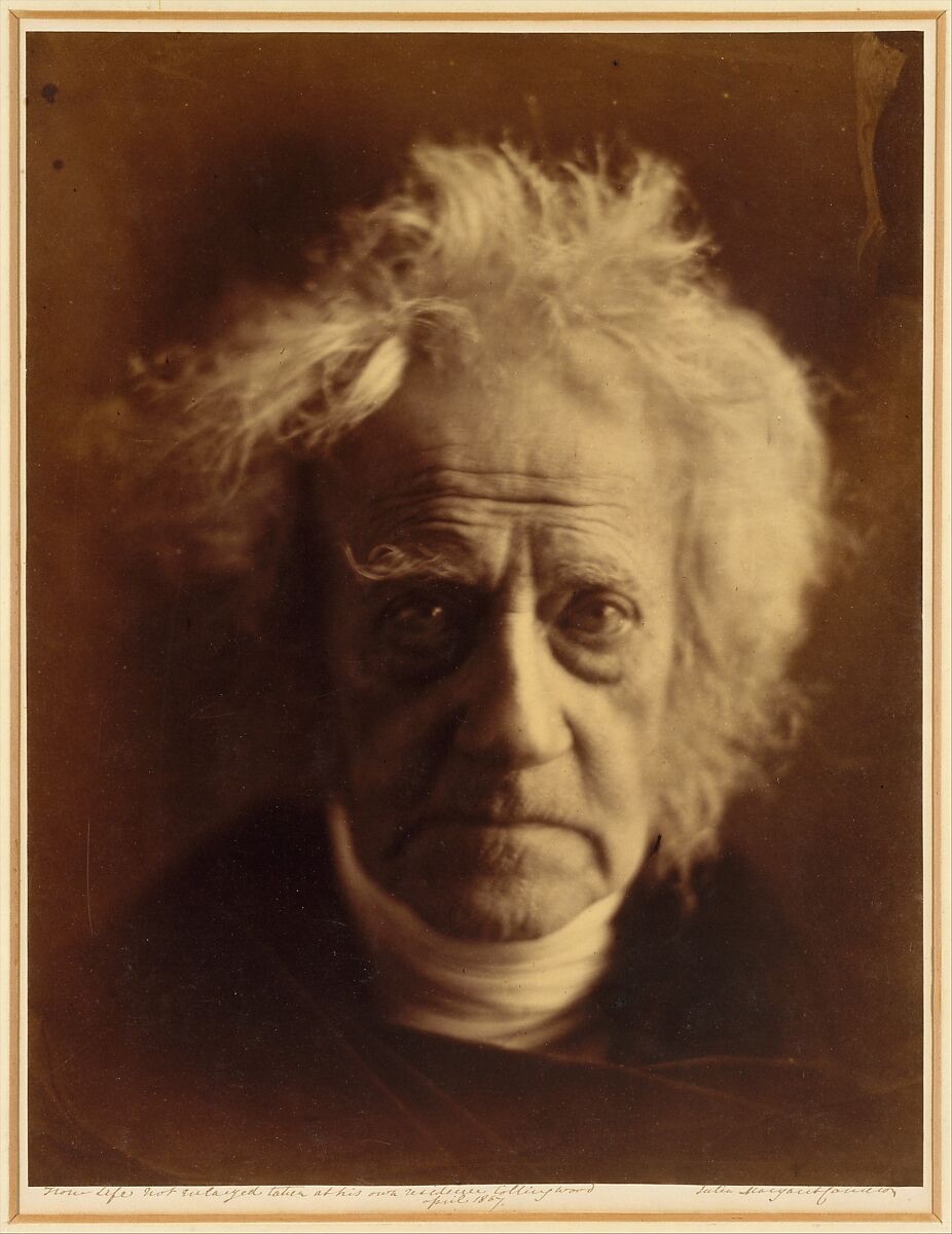 Julia Margaret Cameron portrait of Sir John Herschel, 1867, lit head with white hair emerging from a black background